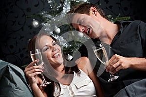 Extravagant couple with champagne on Christmas photo