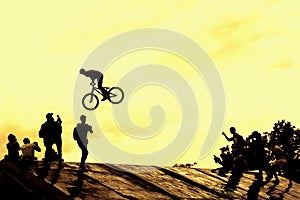 Extrem Sport and risk. Performance at competitions. Silhouette of unidentified young man performs stunts on background