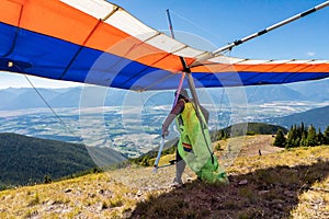 Extremal man with hang-glider preparing to fly