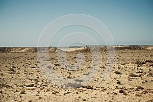 Extreme adventures or science expedition in a stone desert. Sahara desert at sunrise - mountain landscape with dust on skyline,