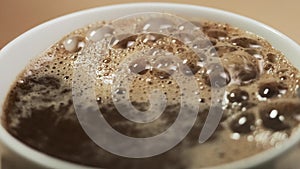 Extreme close-up brewing coffee in a mug. Puring hot water into the white cup