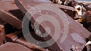 extreme close-up detailed broken pieces of bittersweet chocolate with whole hazelnuts