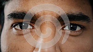 Extreme close up face of young arabian male adult model man male eyes with dark eyeballs stare looking at camera show