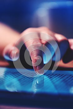 Extreme close up of female finger using digital tablet computer