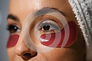 Extreme close up of gel eye patches on female face. Beautiful young Caucasian woman with eye patches on face. Skincare