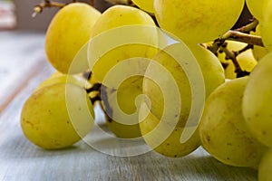 Extreme close-up of green grapes to produce white wine, on wooden table