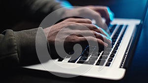 Extreme close-up hands of unrecognizable hacker programmer working typing on keyboard laptop.