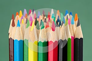 Extreme close up of a lare group of colorful penExtreme close up of a large group of colorful pencils against green background