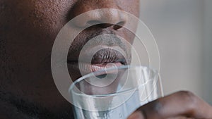Extreme close up male face african american millennial man taste refreshing mineral liquid drink pure clear fresh cold
