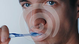 Extreme close up man`s mouth as he brushes his teeth on isolated white background