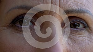 Extreme close-up of mature woman eyes, sad retired lady looking into camera