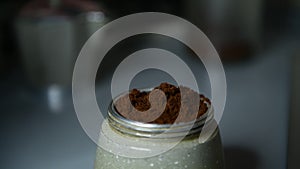 Extreme close up of moka with ground coffee and hands are assembling