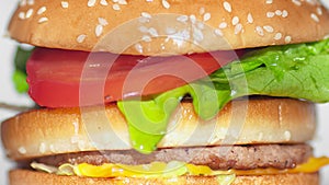 Extreme close-up piece of bread falling on finished appetizing burger