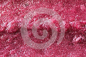 Extreme close-up of a purple grape popsicle with ice crystals and texture; background