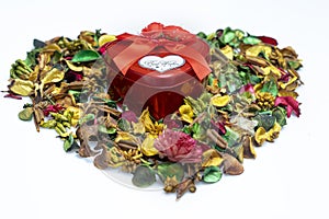 Close up of A red heart metal gift box on colorful dried flowers used as wallpaper