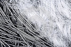 Extreme close up, top down view of polypropylene filament micro fibers and steel, end hooked fibers for concrete structural