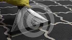 Extreme close-up of unrecognizable cleaning service employee male in yellow rubber gloves vacuuming dirty and dusty