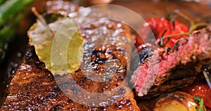 Extreme close up view of a sirloin steak with asparagus, potatoes and roasted tomatoes