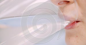 Extreme close up of woman drinking glass of water