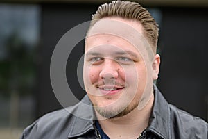 Extreme close up of a young man in a black leather jacket and slicked back hair photo