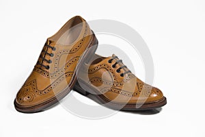 Extreme Closeup of Brogue Derby Shoes of Calf Leather with Rubber Sole On One Another Over Pure White Background