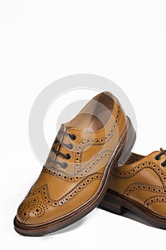 Extreme Closeup of Brogue Derby Shoes of Calf Leather with Rubber Sole On One Another Over Pure White Background