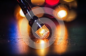 Extreme closeup of christmas garland vitage light bulb on defocused lights bokeh background. Christmas decoration, New Years Eve.