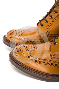 Extreme Closeup of Mens Tanned Brogue Leather Boots with Rubber Sole