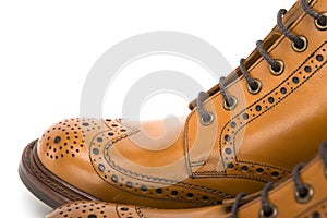 Extreme Closeup of Mens Tanned Brogue Leather Boots with Rubber Sole