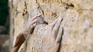 Extreme closeup orange limestone cliff and woman`s hands reaching and holding holds.
