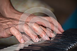 Extreme closeup scene of a man playing piano, hands only.