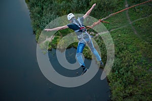 Extreme jump from the bridge. The man jumps surprisingly quickly in bungee jumping at Sky Park explores extreme fun. Bungee in the photo