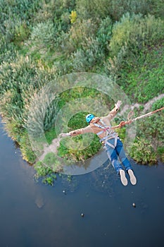 Extreme jump from the bridge. The man jumps surprisingly quickly in bungee jumping at Sky Park explores extreme fun. Bungee in the