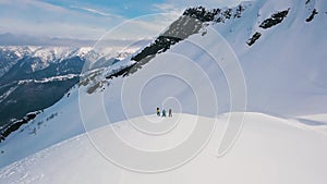 Extreme long shot group of active sport people standing on top of mountain surrounded by snow