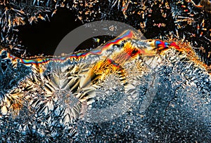 Extreme macro photograph of Vitamin C crystals forming abstract modern art patterns, when illuminated with polarized