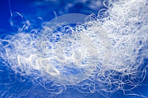 Extreme macro of polyester stable fiber on blue background