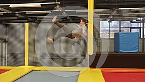 Extreme man is performing jumps with somersaults on a trampolines