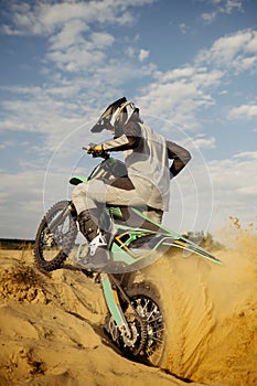 Extreme motocross rider riding on dirt track