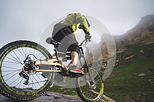 Extreme mountain bike sports athlete man in helmet riding outdoors against a background of rocks. Lifestyle. Trial