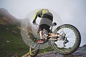 Extreme mountain bike sports athlete man in helmet riding outdoors against a background of rocks. Lifestyle. Trial