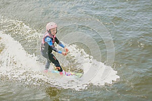 Extreme Park, Kiev, Ukraine, 07 may 2017 - a little girl to ride a Wakeboard. Photo of grain processing