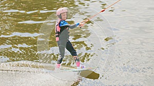 Extreme Park, Kiev, Ukraine, 07 may 2017 - a little girl to ride a Wakeboard. Photo of grain processing