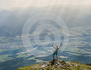 Extreme runner finally climbs the mountain top and see wide valley