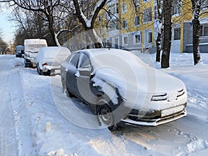 Extreme snow after heavy snow strom, Parked cars covered snow near yellow resident building