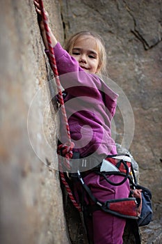 Extreme sport, active lifestyle, kid with a rope engaged in the sports of rock climbing on the rock