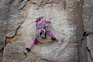 Extreme sport, active lifestyle, kid with a rope engaged in the sports of rock climbing on the rock