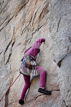 Extreme sport, active lifestyle, kid with a rope engaged in the sports of rock climbing on the rock