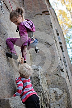 Extreme sport, active lifestyle, kid with a rope engaged in the sports of rock climbing on the rock