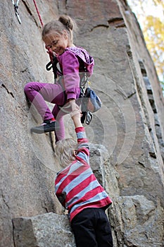 Extreme sport, active lifestyle, kid with a rope engaged in the sports of rock climbing on the rock