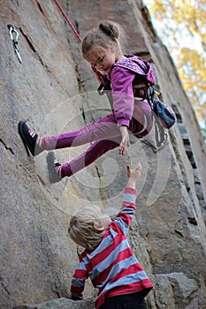 Extreme sport, active lifestyle, kid with a rope engaged in the sports of rock climbing on the rock